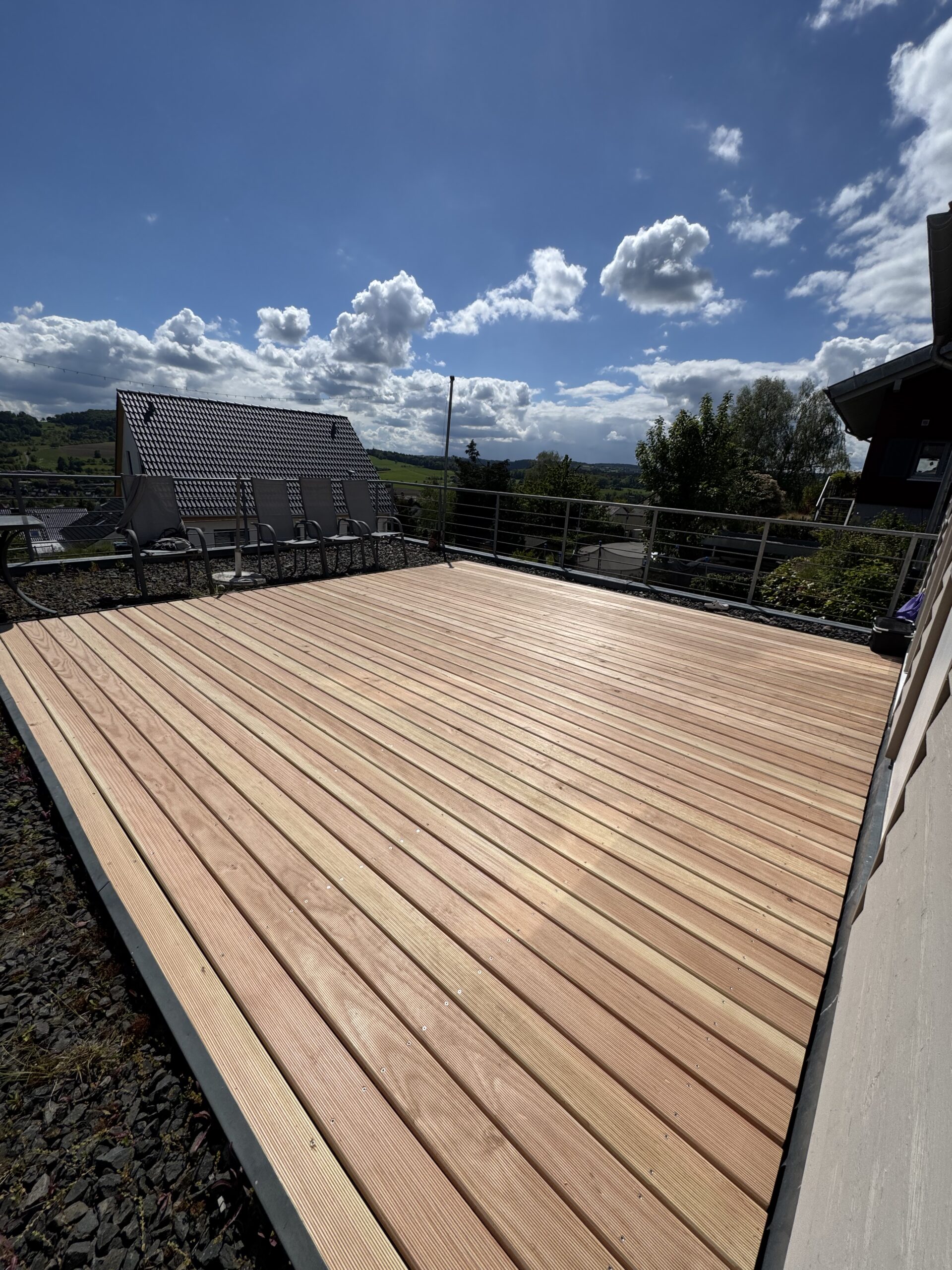Sonnige Holzterrasse mit Geländer